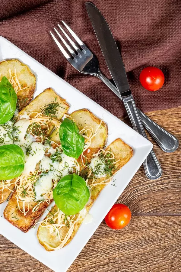 Baked zucchini with suluguni cheese, mozzarella and fresh basil leaves