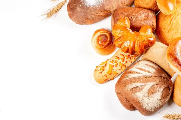 Bakery product assortment with bread loaves, buns, rolls and pies on white, top view