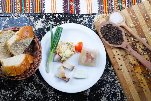 Balkan breakfast with bacon, pork jelly, onion and beef salad served with bread. Traditional meal (Flip 2019)