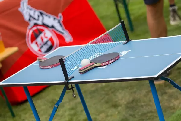 Ball und zwei Schlägern auf einem Tischtennistisch