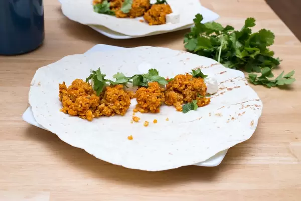 Balls made of red lentils with ajvar dip and cheese cubes