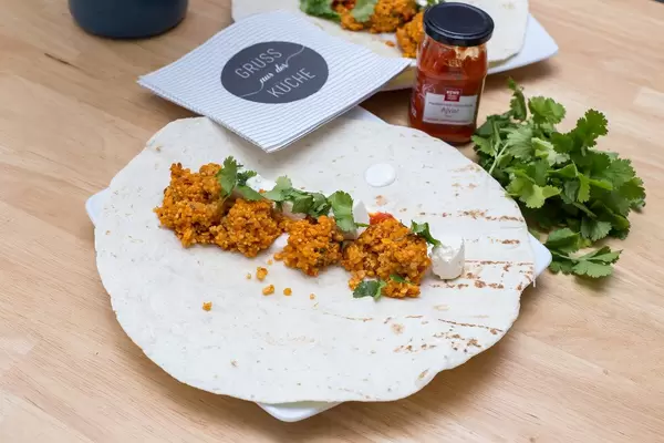 Balls made of red lentils with ajvar dip, cheese cubes and parsley