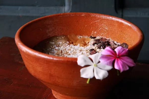 Banana Smoothie Bowl with coconut flakes, raw chocolate, peanut butter and sesame seeds