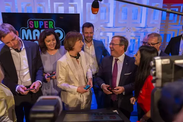 Bär, Reker und Laschet spielen Super Mario Party am Nintendo Messestand