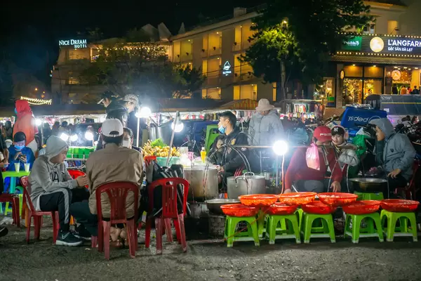Barbecue Street Food with People sitting on Plastic Chairs at the Dalat Night Market in Vietnam