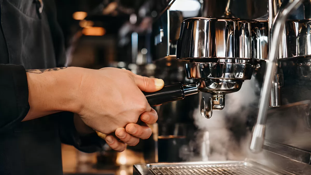 Barista befestigt Siebträger an professioneller Espressomaschine