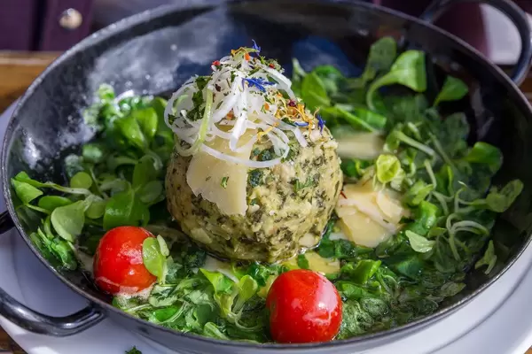 Bärlauch Knödel in der Pfanne mit Feldsalat und Cherry-Tomaten bei der Dauerstoa Alm in Alpbach