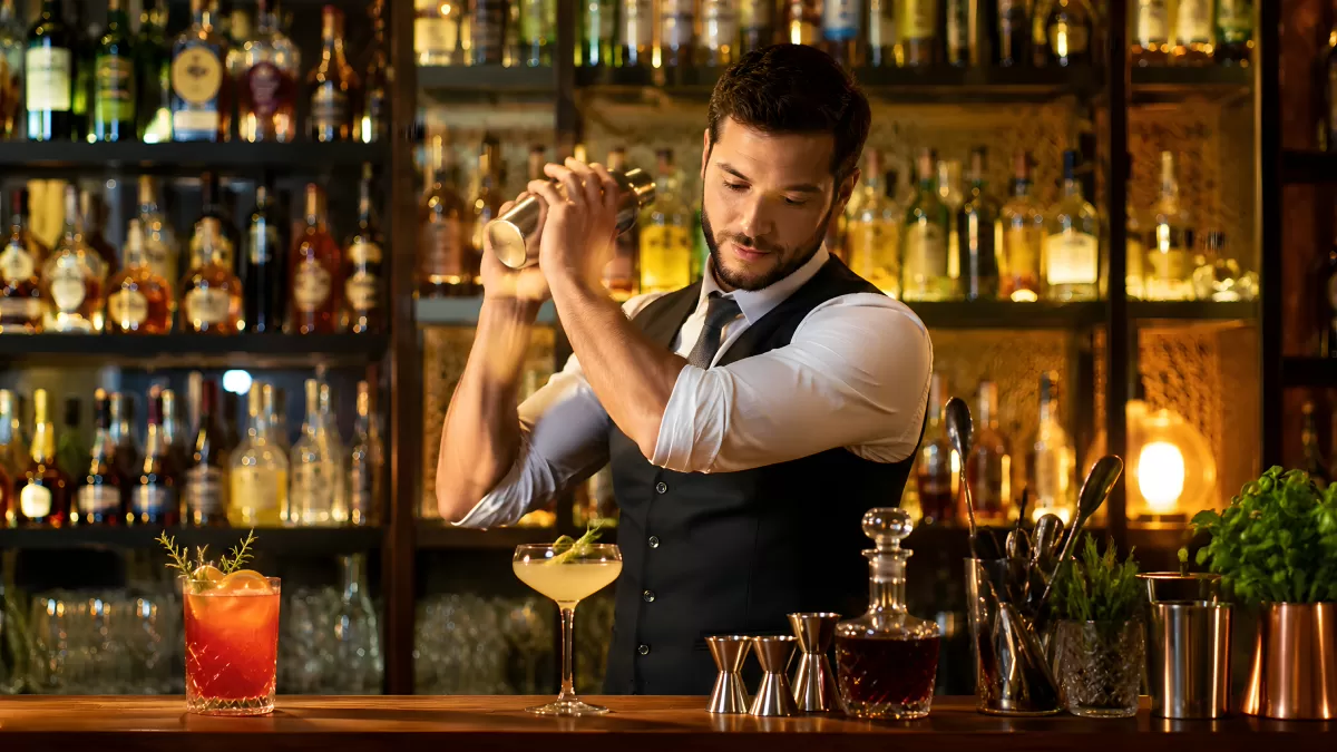 Bartender mixt Cocktails hinter einer beleuchteten Bar