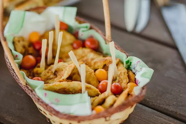 Basket With Pancakes And Tomatoes On Wooden Table