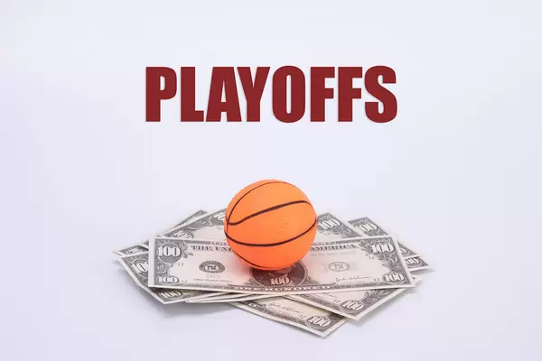 Basketball ball on US dollar banknotes with Playoffs text
