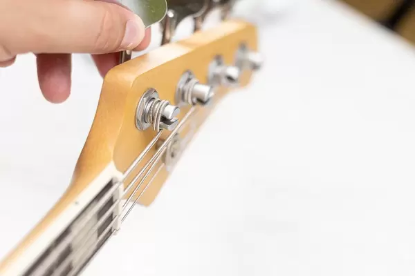 Bass Guitarist adjusts the strings on the guitar