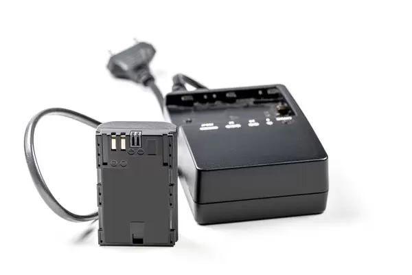 Battery to camera with charger on white background (Flip 2020)