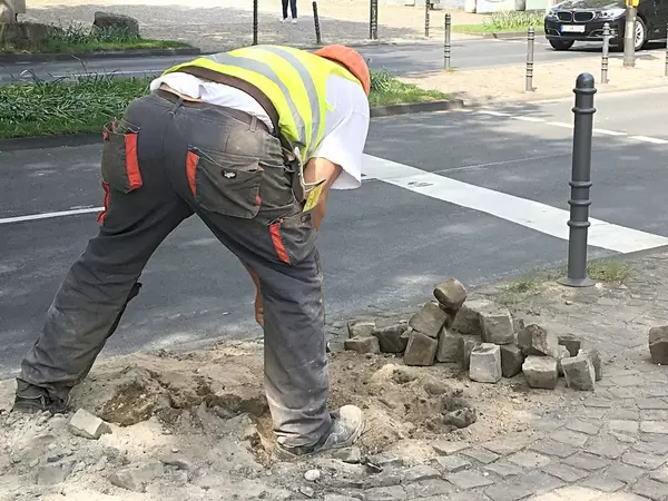 Bauarbeiter und Pflastersteine auf Baustelle