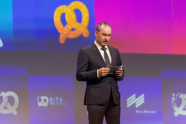 Bayrischer Wirtschaftsminister Hubert Aiwanger hält eine englische Rede vor internationalem Publikum auf der Gründermesse Bits & Pretzels