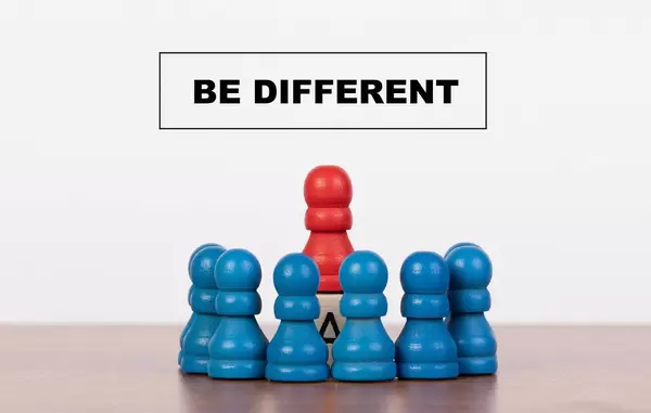 Be different concept with pawn figurines on table