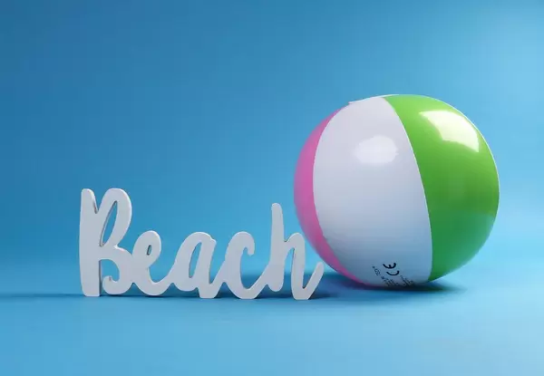 Beach ball with beach text on blue background