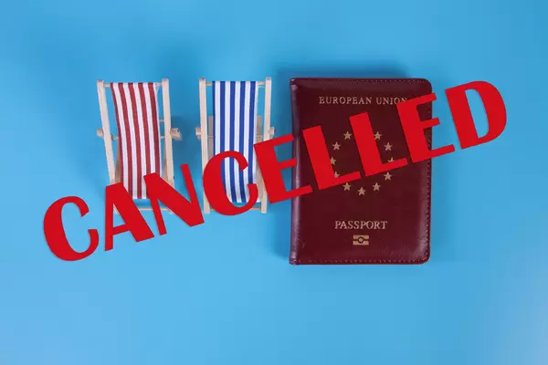 Beach chairs with passport and Cancelled text on blu background