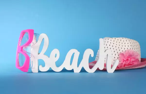 Beach text with diving mask and summer hat on blue background