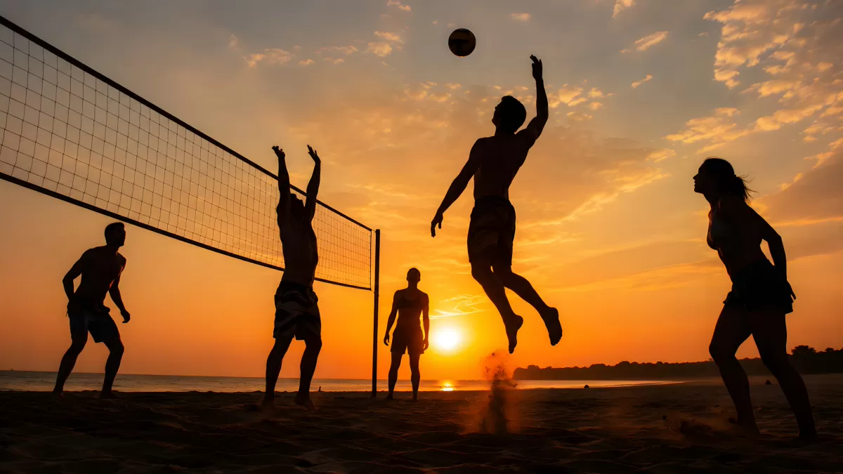 Beachvolleyball-Gruppe spielt bei Sonnenuntergang am Strand