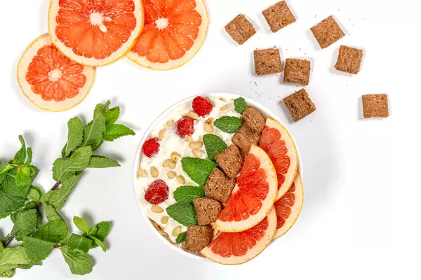 Beautiful breakfast background with oatmeal grapefruit, mint and chocolate pads, top view