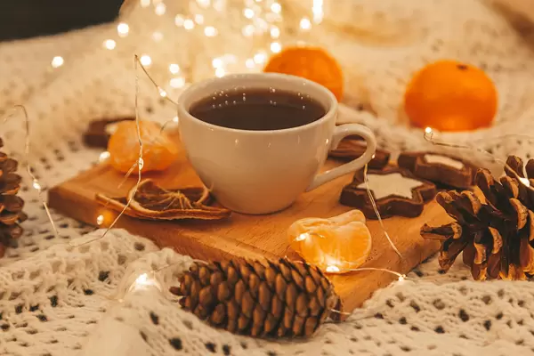 Beautiful christmas background with garland, coffee and decor on knitted fabric