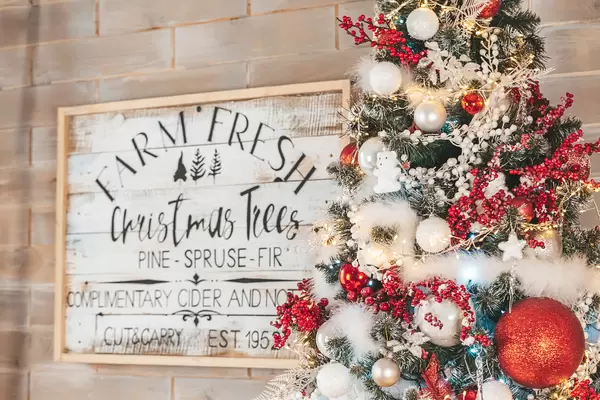 Beautiful decorated christmas tree with wooden signboard on the wall