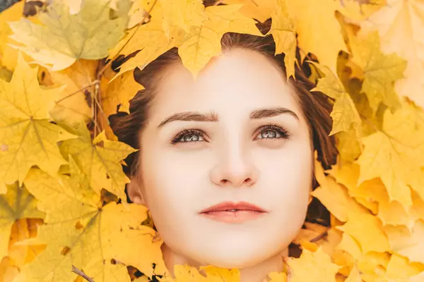 Beautiful elegant woman portrait with autumn leaves