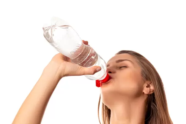 Beautiful girl drinking water from bottle