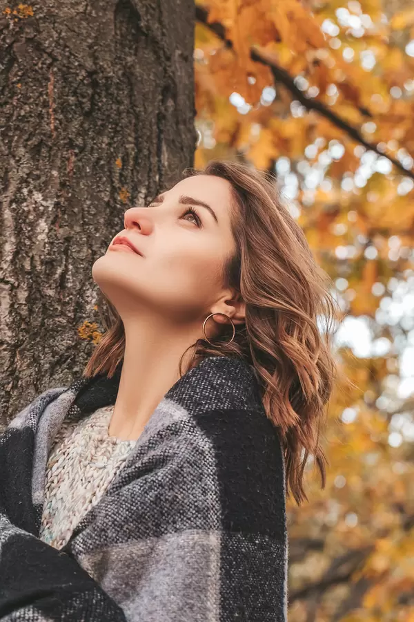 Beautiful girl resting in the park in autumn