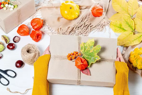 Beautifully packaged gift in autumn style in women's hands. Family holiday concept, Thanksgiving Day (Flip 2019)