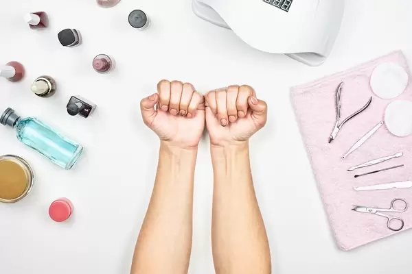 Beauty and nail care concept. Female hands and manicure different accessories on white