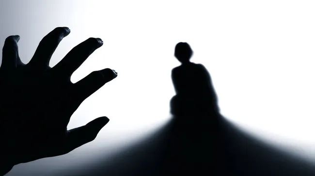 Bedrohliche Silhouette und dunkle Hand im Dunst