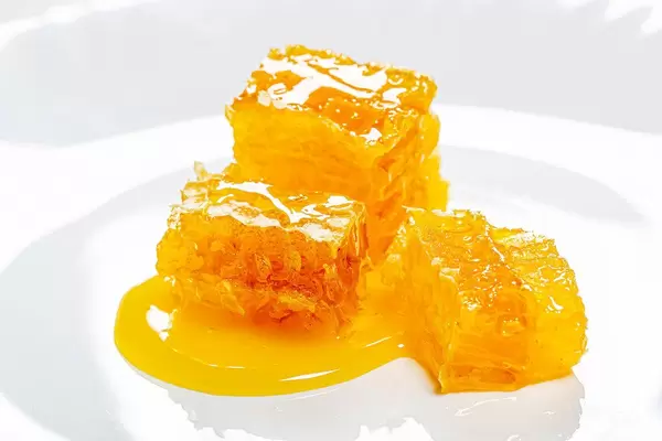 Bee honeycomb and honey on a white plate