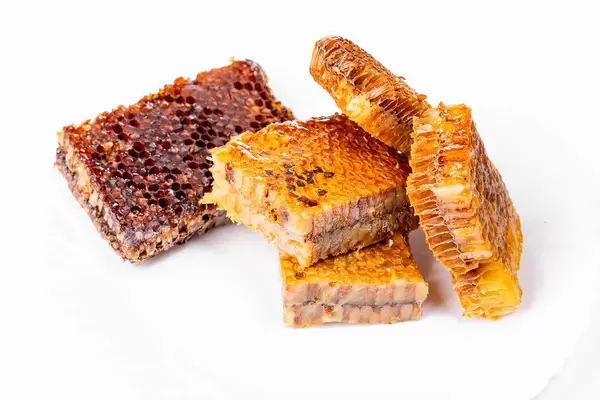 Bee honeycombs filled with honey in white background