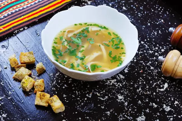 Beef Frittatensuppe with croutons, black background (Flip 2019)