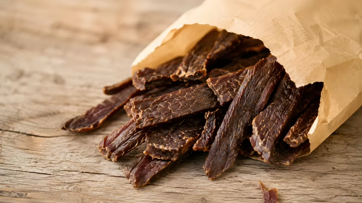 Beef Jerky aus einer Papiertüte auf Holzuntergrund
