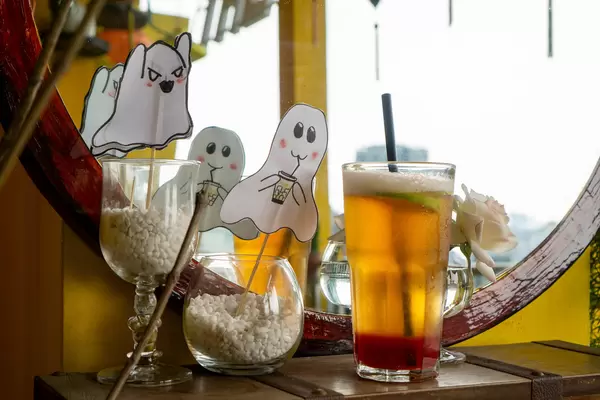Beer with Strawberry Flavor on a Chest Box next to Halloween Decorations on a Balcony of a Cafe