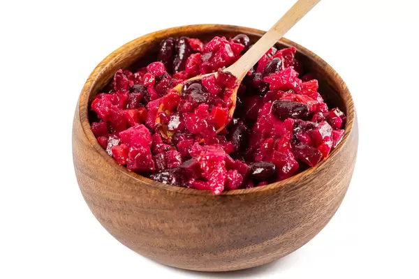 Beetroot salad vinaigrette in wooden bowl with wooden spoon