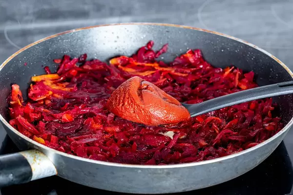 Beetroot with carrots and onions fried in a frying pan and add a spoon tomato sauce