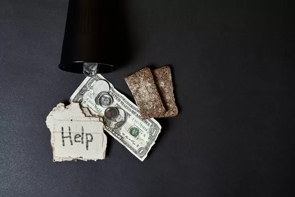 Beggar can with slices of moldy bread, coins and coins