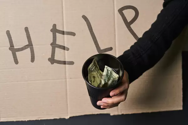 Beggar showing Help sign on cardboard