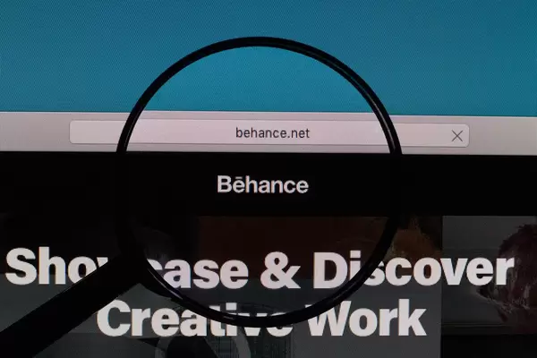 Behance logo under magnifying glass