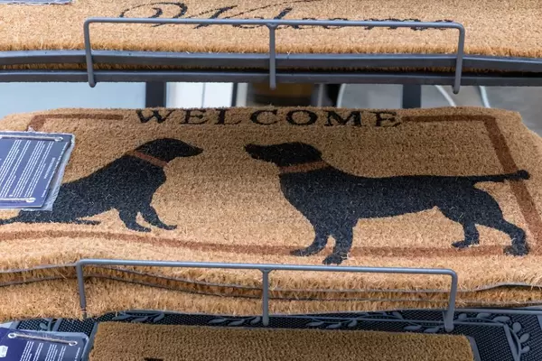 Beige Fußabtreter für Haustüre mit schwarzen Hunden und der Aufschrift Welcome