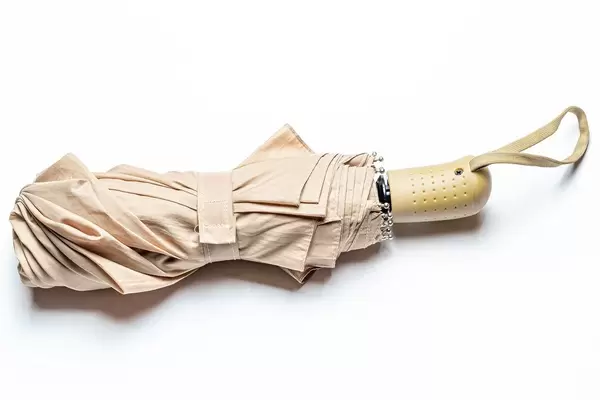 Beige umbrella on a white background, top view