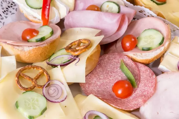 Belegte Brötchen mit Käse, Salami und Schinken mit Gurken und Tomaten