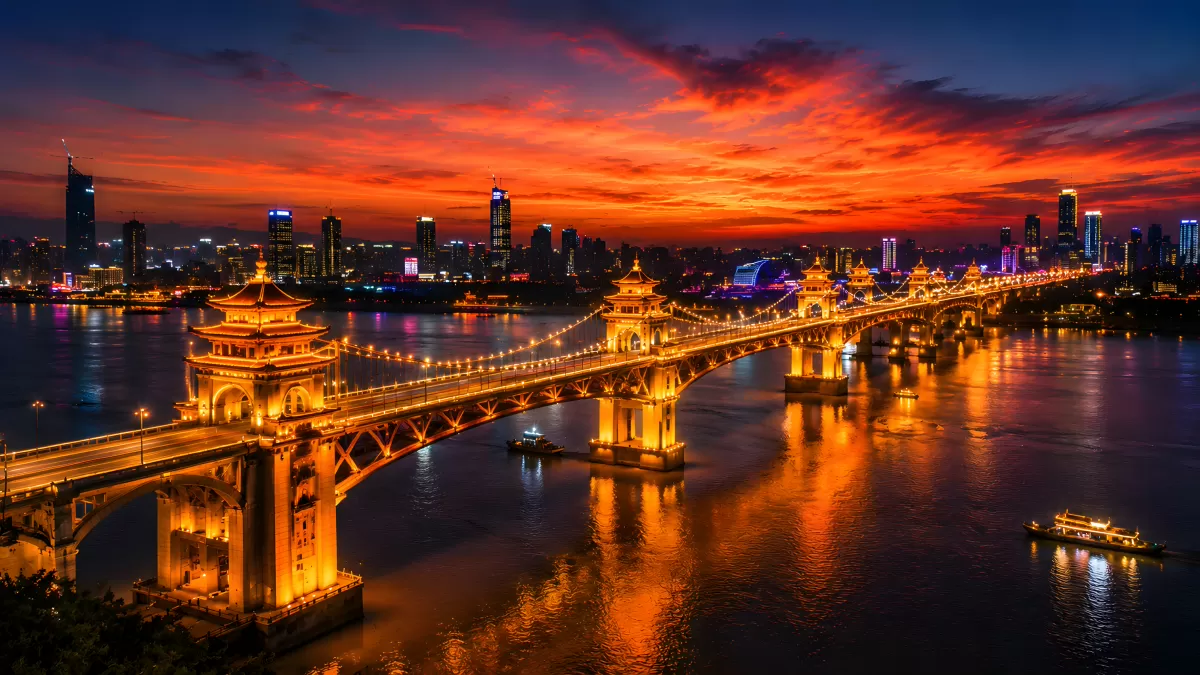 Beleuchtete Brücke über einen Fluss bei Sonnenuntergang