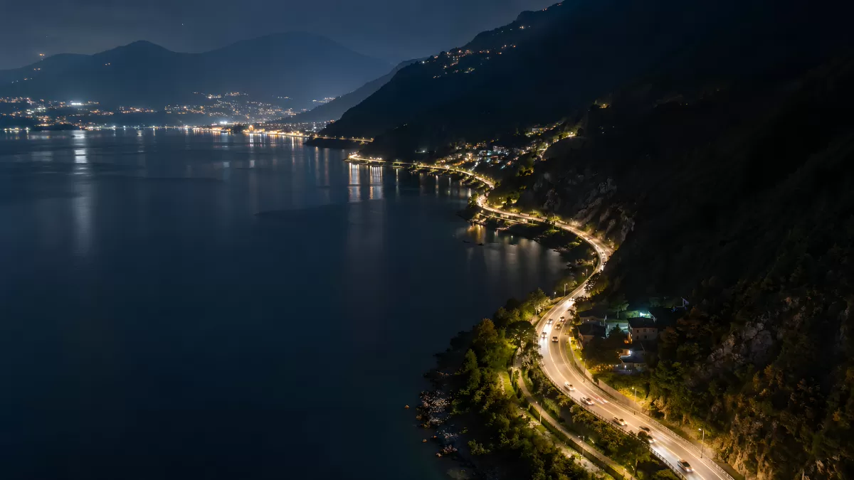 Beleuchtete Küstenstraße am See in der Nacht