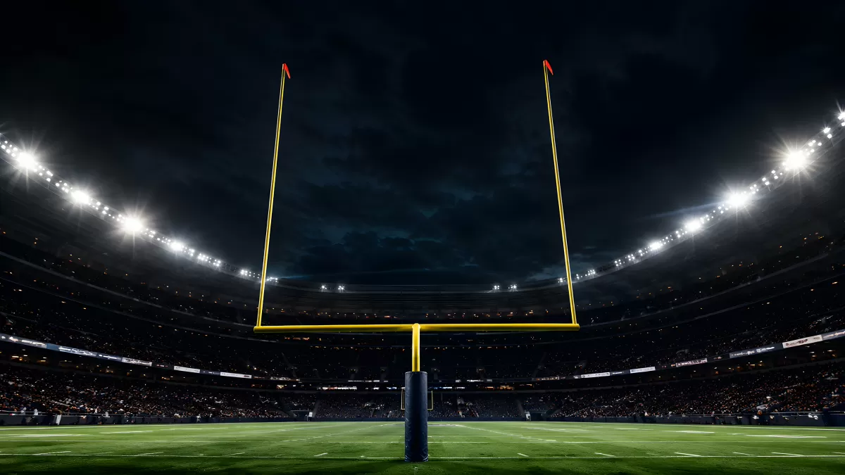 Beleuchtetes Football-Stadion bei Nacht mit Torpfosten
