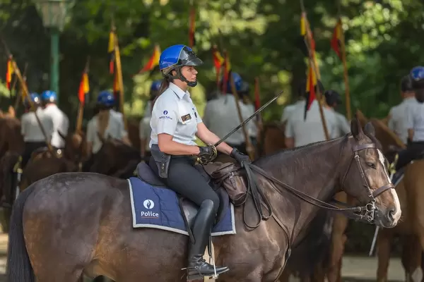 Belgian policewoman sits on a horse with a sword in her hand in Brussels, Belgium