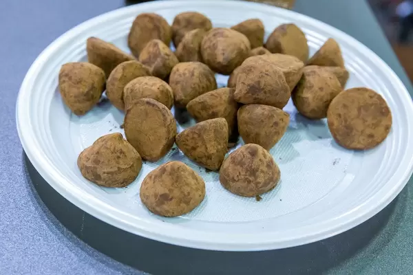 Belgische Trüffel von Bianca mit Kakaopulver bestäubt und in Einweg-Plastikteller serviert